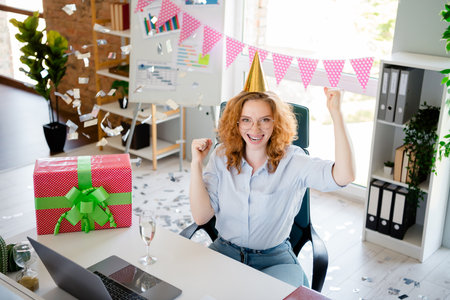 Photo of young girl celebrate birthday giftbox winning wear formalwear modern office business consultant room interior indoors workspaceの写真素材
