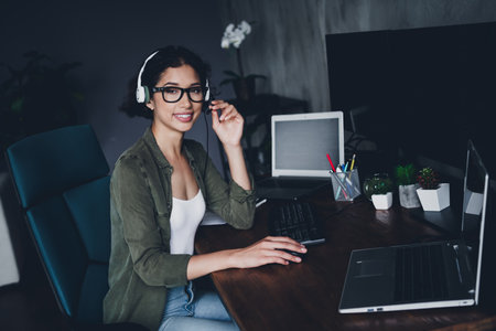 Female programmer working in a modern home office setting with advanced equipment and casual style