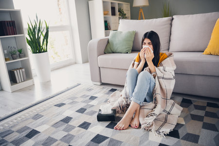 Young woman with brunette hair relaxes in cozy living room indoors on weekendの写真素材