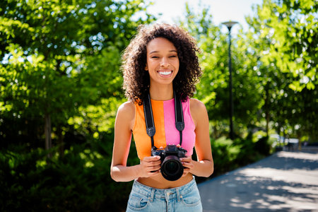 Photo of pretty young woman hold camera photographer wear colorful clothes walk outside urban...