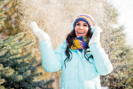 Photo of funky lady enjoy falling snow listen music wear earphones hat scarf gloves coat in winter park outdoorsの写真素材