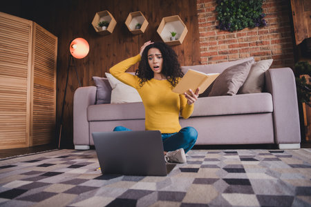 Young woman studying at home on laptop feeling surprised with results