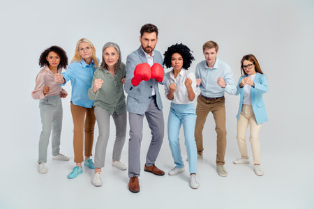 Diverse group of business professionals in formal attire posing together showcasing unity and teamwork in a dynamic studioの写真素材