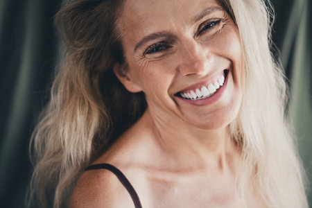 Studio no retouch photo of good mood cheerful lady dressed lingerie accepting imperfect skin isolated khaki cloth backgroundの写真素材