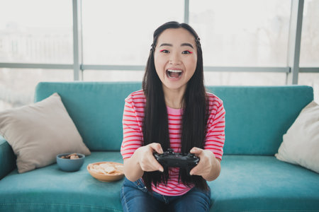 Young cheerful woman with a bright smile enjoying indoor leisure in a modern living room with a...