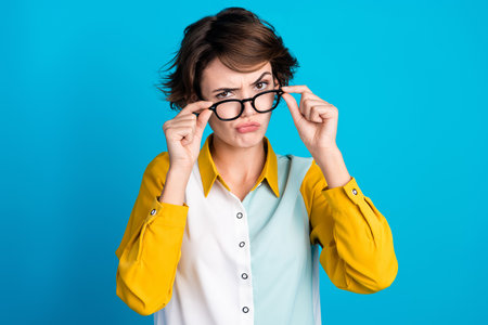 Photo of suspicious distrustful lady look touch spectacles isolated over blue color background