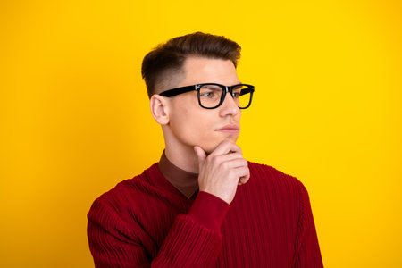 Young Man in Red Sweater Pondering Against Bright Yellow Background in Casual Style