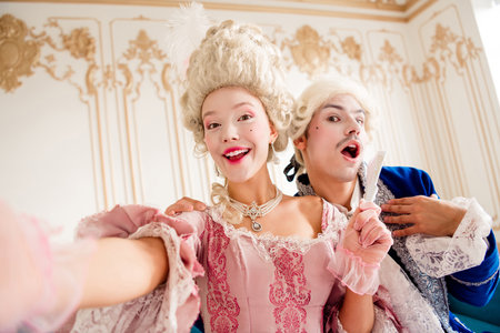 Elegant couple dressed in baroque costumes enjoying a playful moment in a luxurious palace interior.