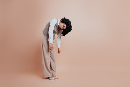 Businesswoman in Elegant Formalwear Posing Against a Beige Backgroundの写真素材