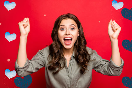 Close up photo of brunette lady in casual shirt wear look at camera with hands up, big eyes and open mouth isolated on shine red backgroundの写真素材