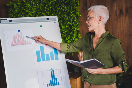 Photo of lovely lady financier assistant dressed shirt showing graphics indoors workplace...
