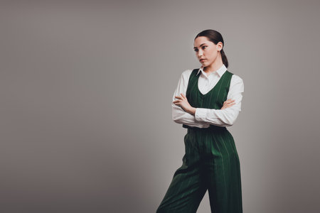 Gorgeous Confident Young Businesswoman in Stylish Green Suit on Neutral Backgroundの写真素材