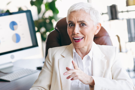 Successful mature businesswoman in a formal office setting illustrates elegance and professionalism at the workplaceの写真素材