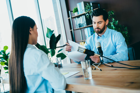 Elegant businessmen and women collaborating on a formal discussion in a professional workspace with...