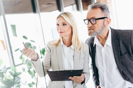 Professional coworkers collaborating on project in a modern office environment embracing teamwork, diversity, and collaborationの写真素材