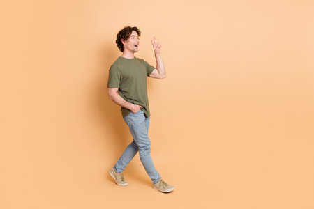 Casual young man with curly hair making peace sign and smilingの写真素材