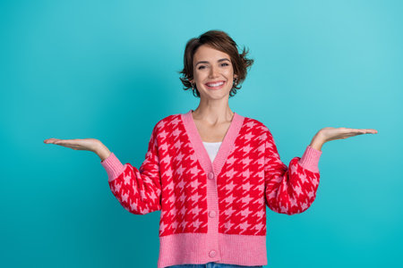 Photo portrait of lovely young lady compare empty space dressed stylish red garment isolated on aquamarine color backgroundの写真素材