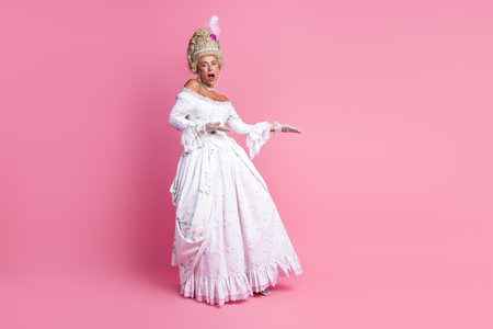 Graceful woman dressed in a vintage white baroque gown posing in a sophisticated and playful manner...