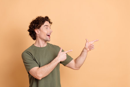 Young happy man in casual green t-shirt making enthusiastic gesturesの写真素材