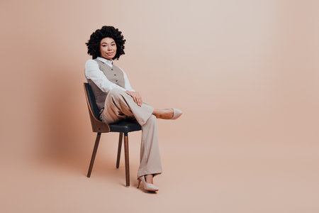 Confident businesswoman posing in stylish formalwear with beige background inspiring professionalism and elegance in a modern settingの写真素材