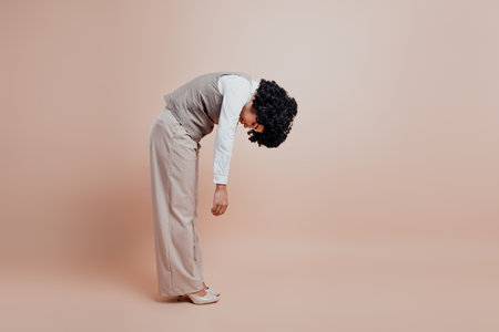 Businesswoman Posing in Beige Formalwear Against a Neutral Background Illustrating Office Fashion and Professional Eleganceの写真素材