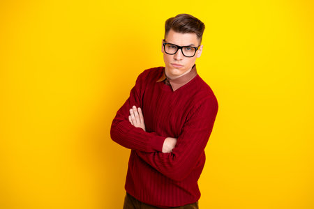 Confident Young Handsome Man in Red Sweater with Confident Expression on Yellow Backgroundの写真素材