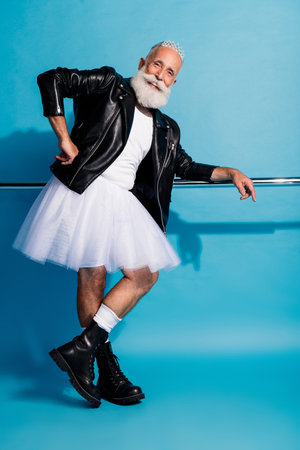 Photo of old man standing after ballet practice wearing dress blazer boots isolated blue color backgroundの写真素材