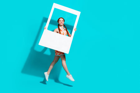 Full size photo of pretty young girl jump empty space wear dress isolated on teal color backgroundの写真素材