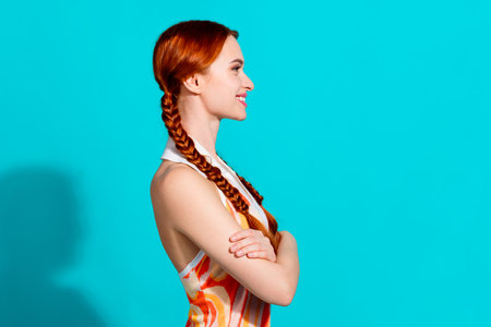 Profile portrait of lovely young woman folded hands empty space wear dress isolated on turquoise color backgroundの写真素材