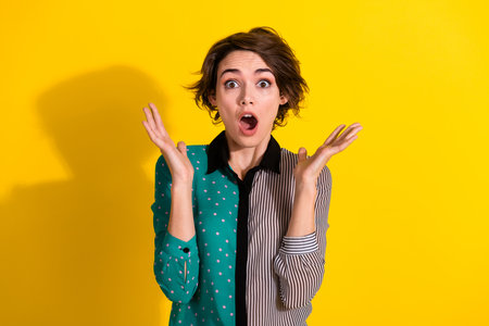 Photo of shocked impressed girl wear stylish print clothes wow news isolated on yellow color backgroundの写真素材