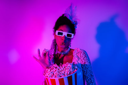 Chic young woman in vintage lace embracing luxury with vibrant neon lights and playful popcornの写真素材