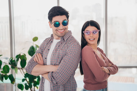 Happy couple joyfully posing together indoors, showcasing casual style and playful expressions against a bright apartment interior.の写真素材