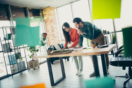 Young professionals collaborating on a creative project in a modern office environment with teamwork and innovationの写真素材