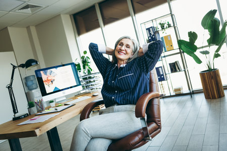 Mature professional woman enjoying her office space, demonstrating confidence and success in a...