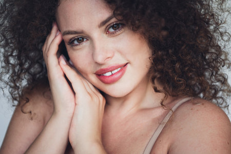 Smiling Woman With Curly Hair Expressing Joy and Confidence in Natural Beautyの写真素材
