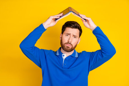 Photo portrait of attractive young man unhappy hold boring book roof dressed stylish blue clothes...