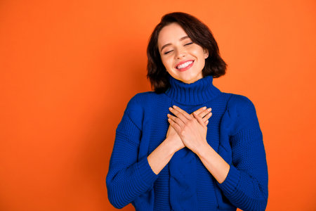Photo of excited style casual toothy cheerful excited ecstatic girl being obviously kind while isolated with orange backgroundの写真素材