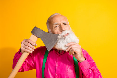 Photo portrait of old gentleman cut beard axe barbershop dressed glamour stylish outfit party isolated vibrant yellow color backgroundの写真素材
