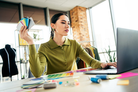 Starting a small business female fashion designer evaluating color samples while working on a business projectの写真素材