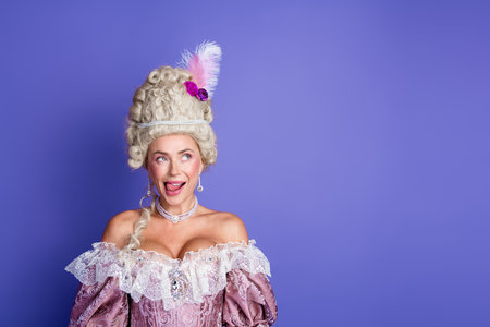 Elegant young woman in a baroque gown with purple background showcasing historical fashion