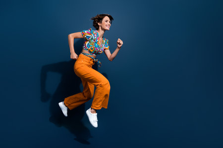 Full length photo of lovely young lady running fast black friday dressed flared pants garment...