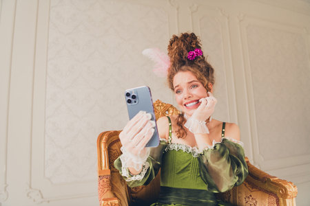 Elegant woman in vintage attire using a modern smartphone in a luxurious interior setting showcasing...