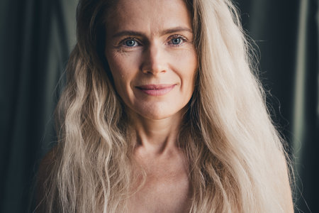 Confident mature woman embracing natural beauty in studio portrait settingの写真素材