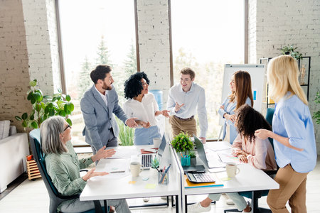 Business professionals collaborating in a modern office workspace during a daytime meetingの写真素材