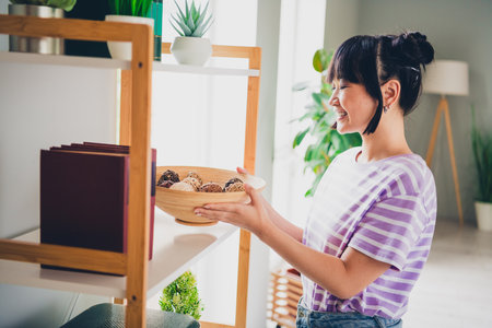 Photo of positive good mood woman dressed striped purple t-shirt changing home decoration indoors house apartment roomの写真素材