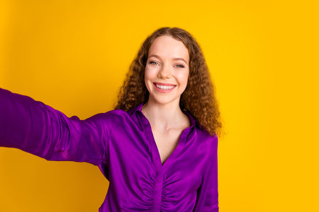 Photo portrait of attractive young woman take selfie photo dressed stylish violet clothes isolated on yellow color backgroundの写真素材