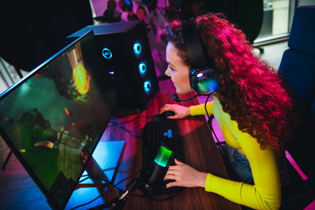 Young woman gaming at home with neon lighting while streaming online in a stylish setup