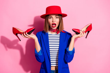 Elegant young woman in stylish colorful outfit with fashion accessories posing against pink backgroundの写真素材