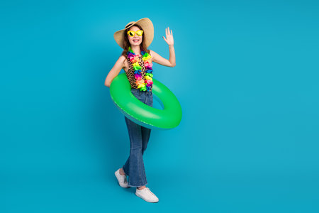 Young Woman in Casual Summer Attire Posing with Bright Accessories and a Green Float on a Vibrant...