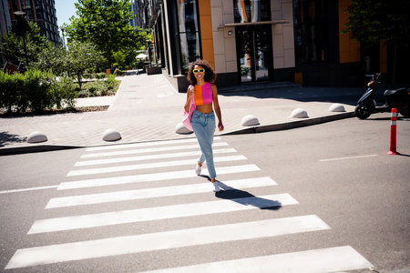 Full body photo of pretty young woman cross street walking travel wear colorful clothes outside urban recreation city parkの写真素材